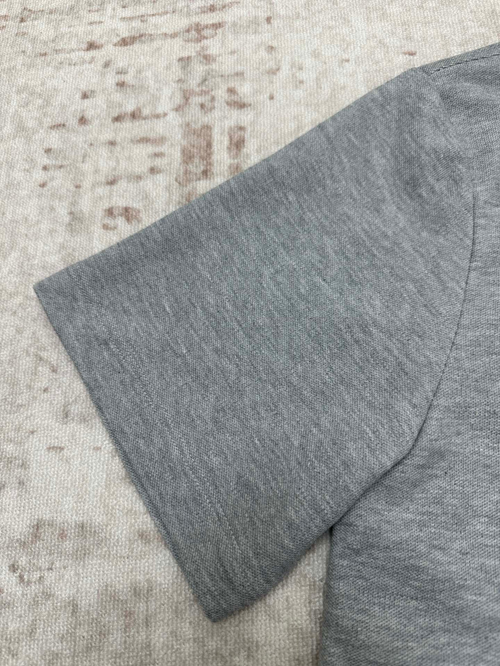 Heather gray polo shirt shoulder and side seam with folded fabric detail
