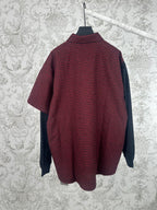 Long-sleeve shirt with red-and-black plaid body and dark navy side panels, button collar