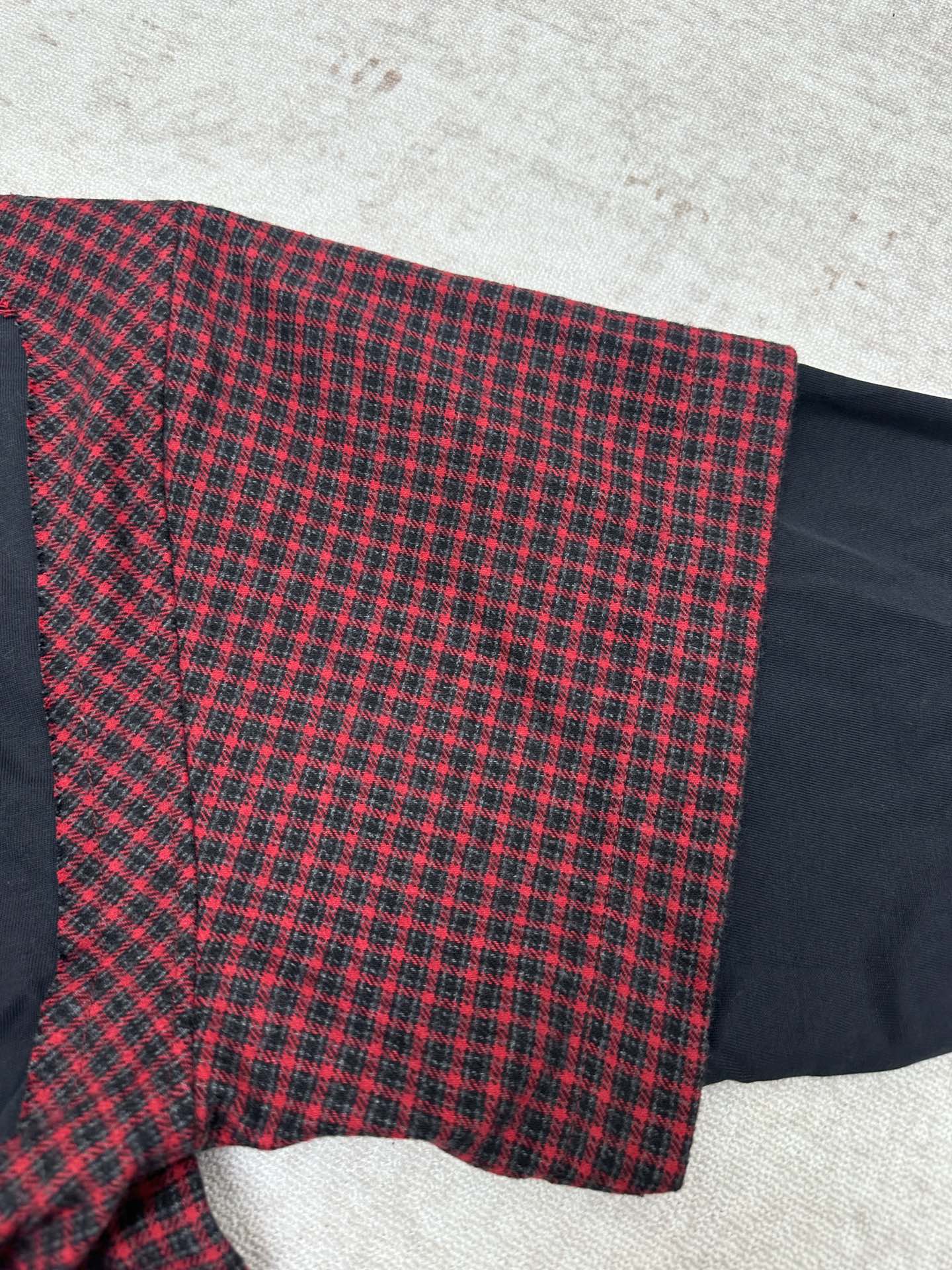 Plaid long-sleeve shirt with flared hem and dark navy underpanel at the side