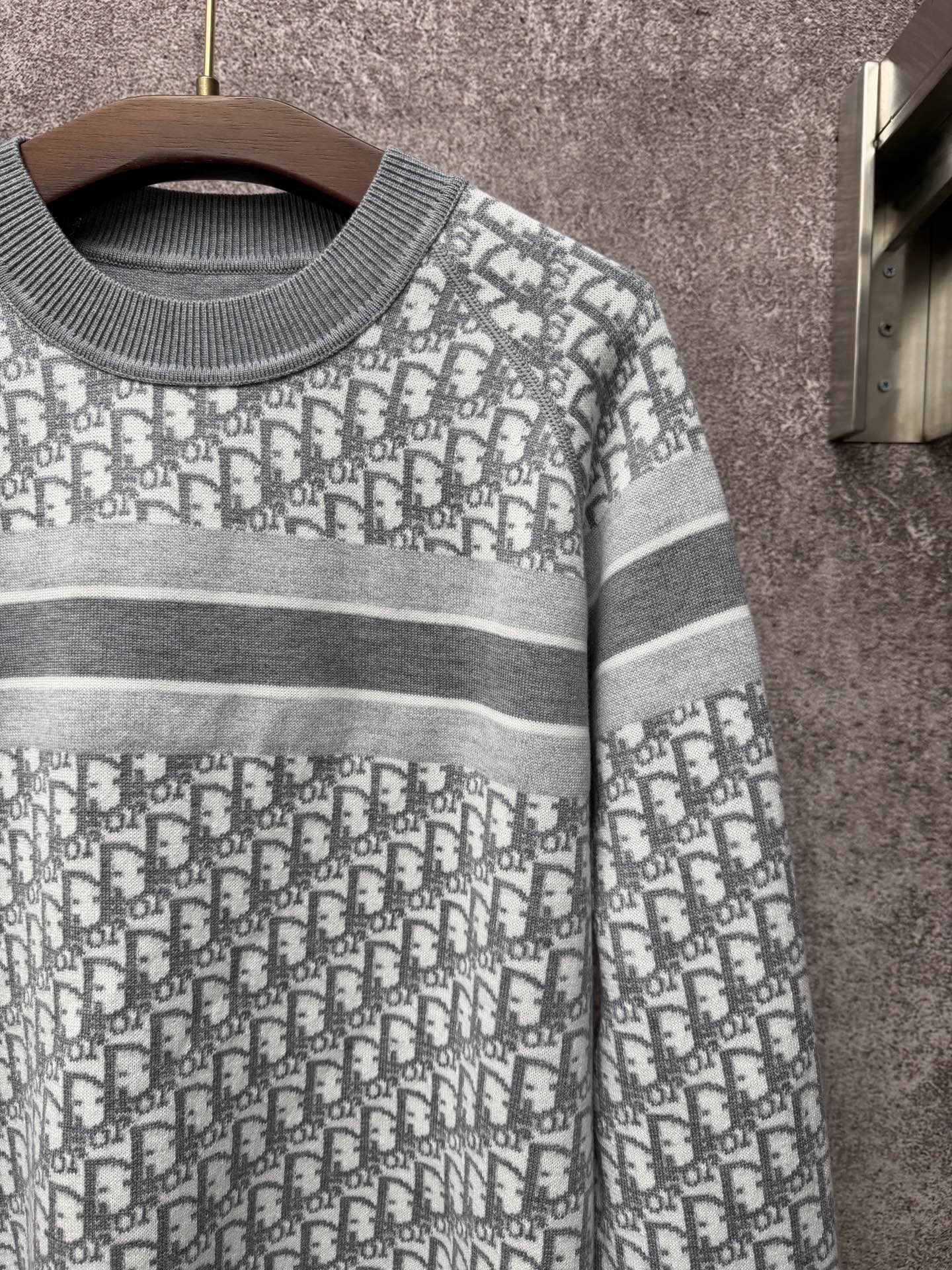Gray-and-white monogram knit sweater with ribbed crew neck and striped trim