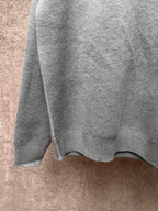 Gray knit sweater side view with ribbed hem and clean shoulder seam