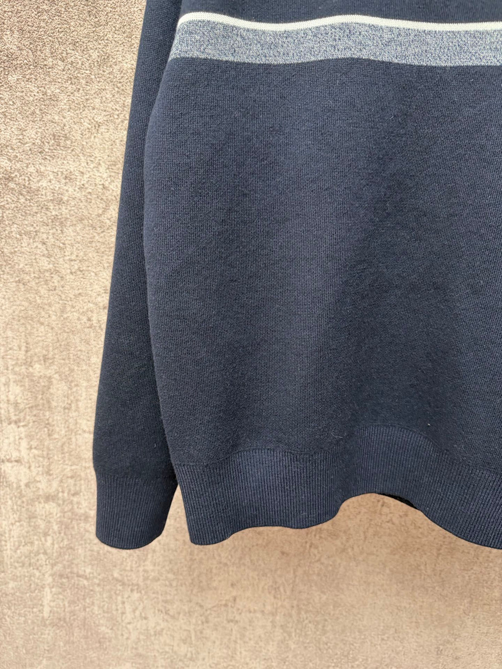 Navy long-sleeve knit sweater with light gray top stripe band visible