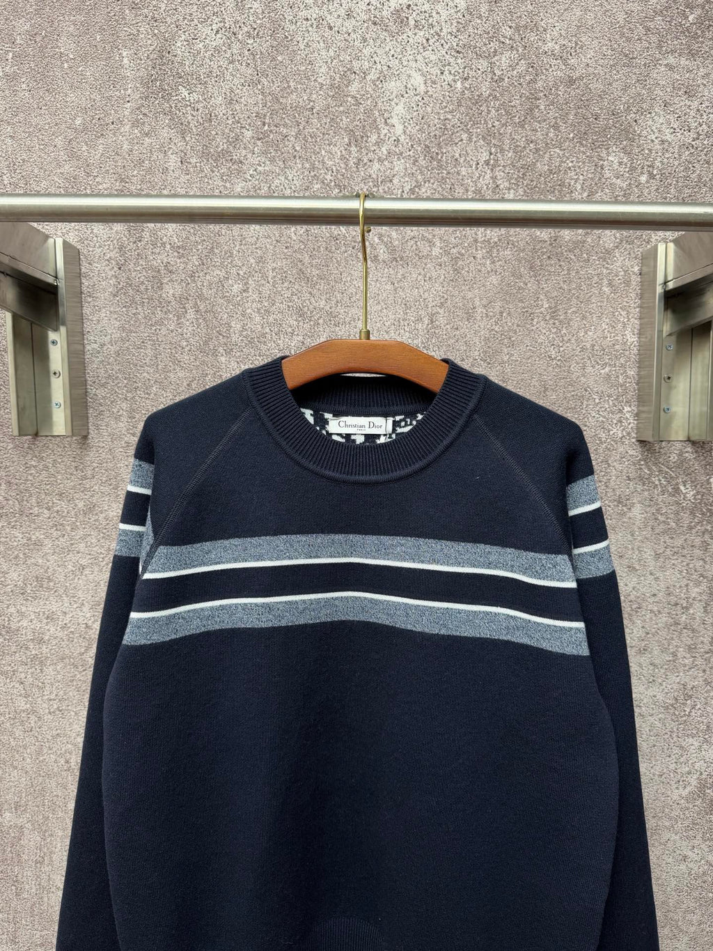 Navy long-sleeve knit sweater with light gray and white horizontal stripe bands