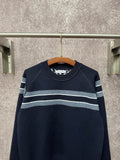 Navy long-sleeve knit sweater with light gray and white horizontal stripe bands