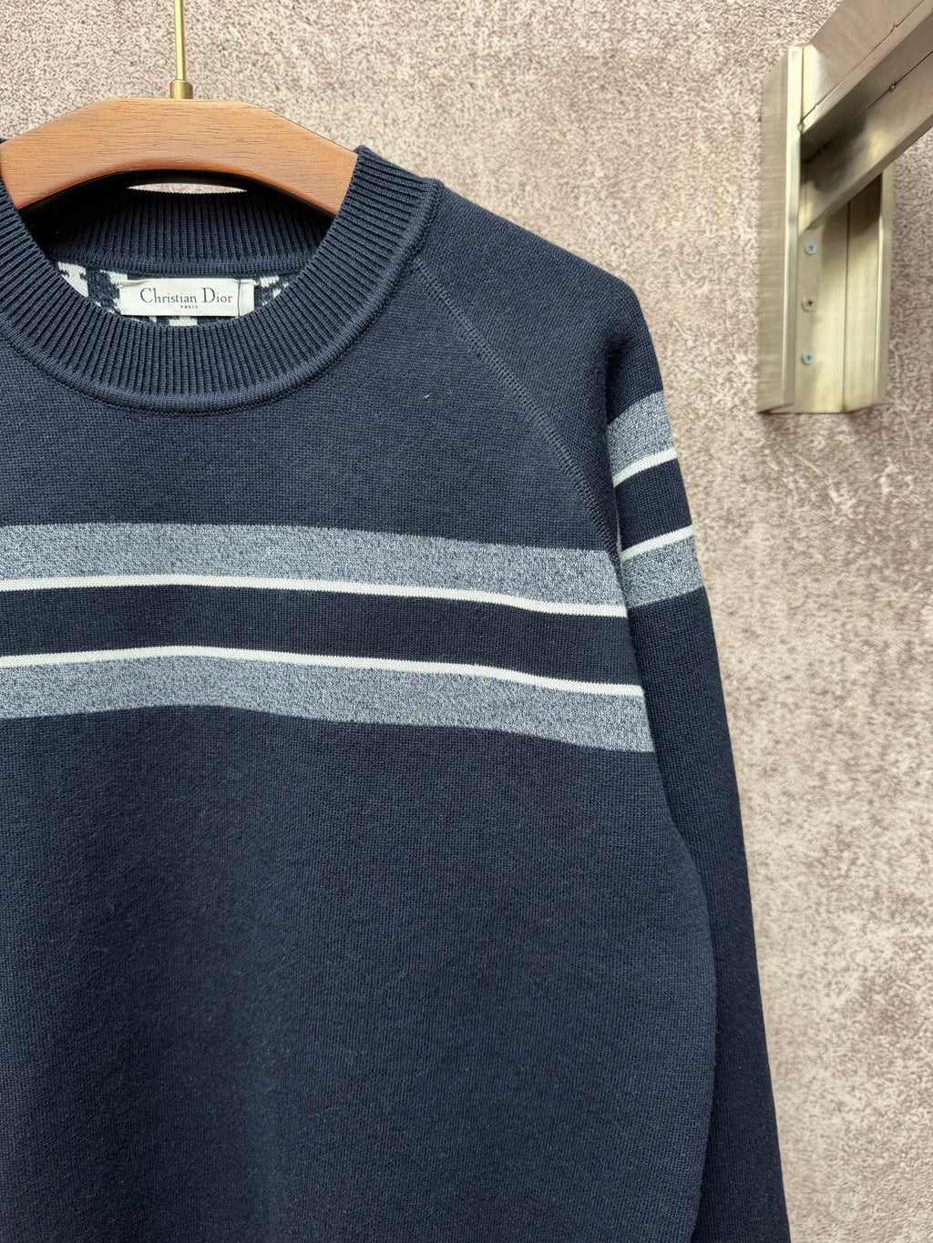Navy knit sweater with wide light gray and white stripe across the chest and sleeves
