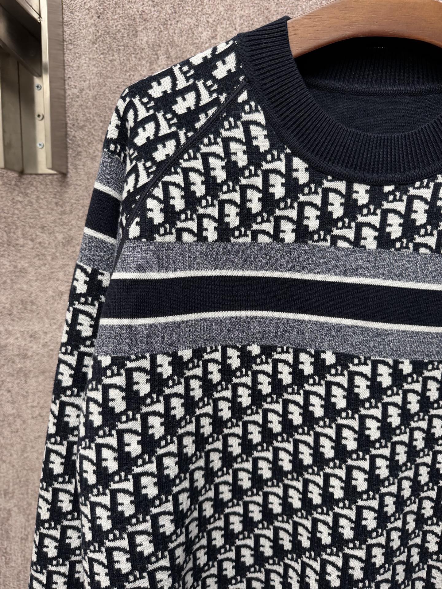 Black and white logo-pattern knit sweater with horizontal stripe bands across chest