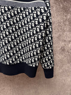 Long-sleeve knit sweater with black and white logo pattern, ribbed hem and cuffs