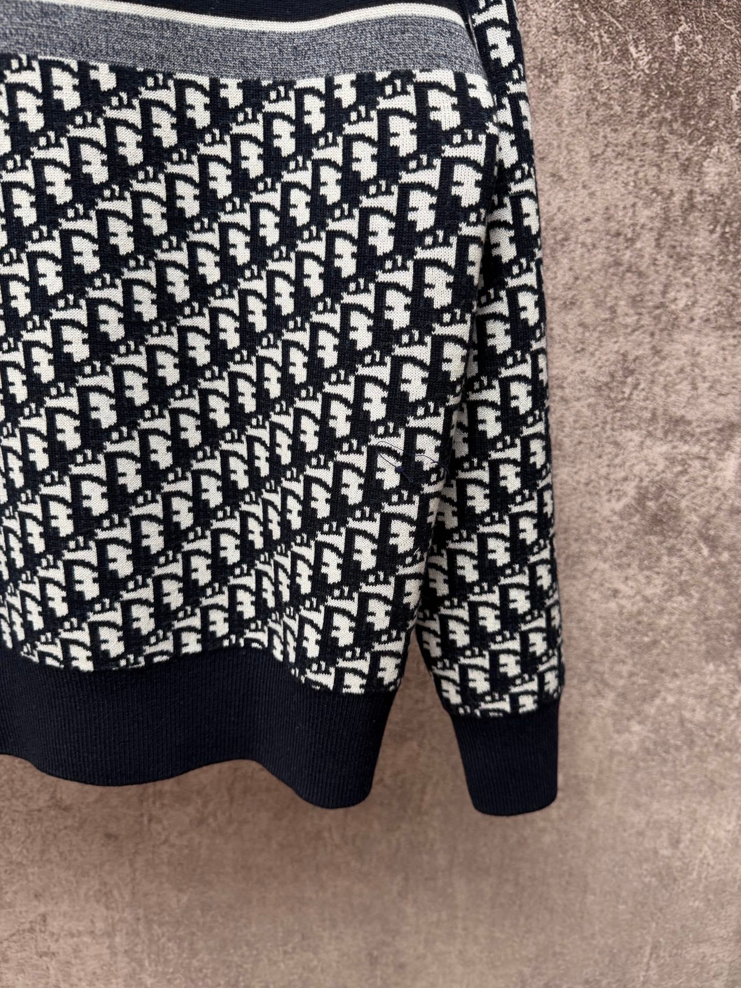 Long-sleeve knit sweater with black and white logo pattern, ribbed hem and cuffs