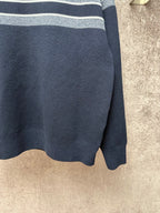 Navy knit sweater hem with light gray and white striped band detail