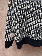 Long-sleeve knit sweater with repeating logo pattern, crew neckline, ribbed cuffs