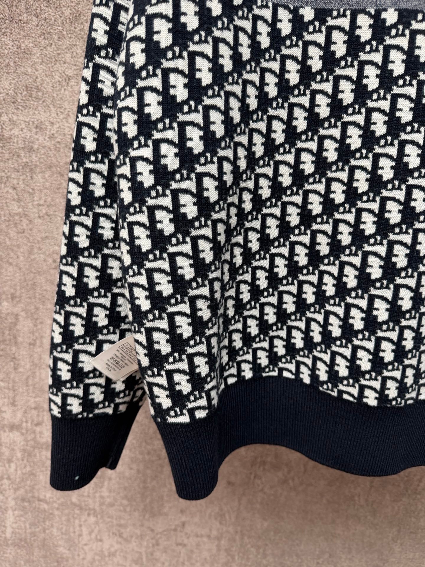 Long-sleeve knit sweater with repeating logo pattern, crew neckline, ribbed cuffs