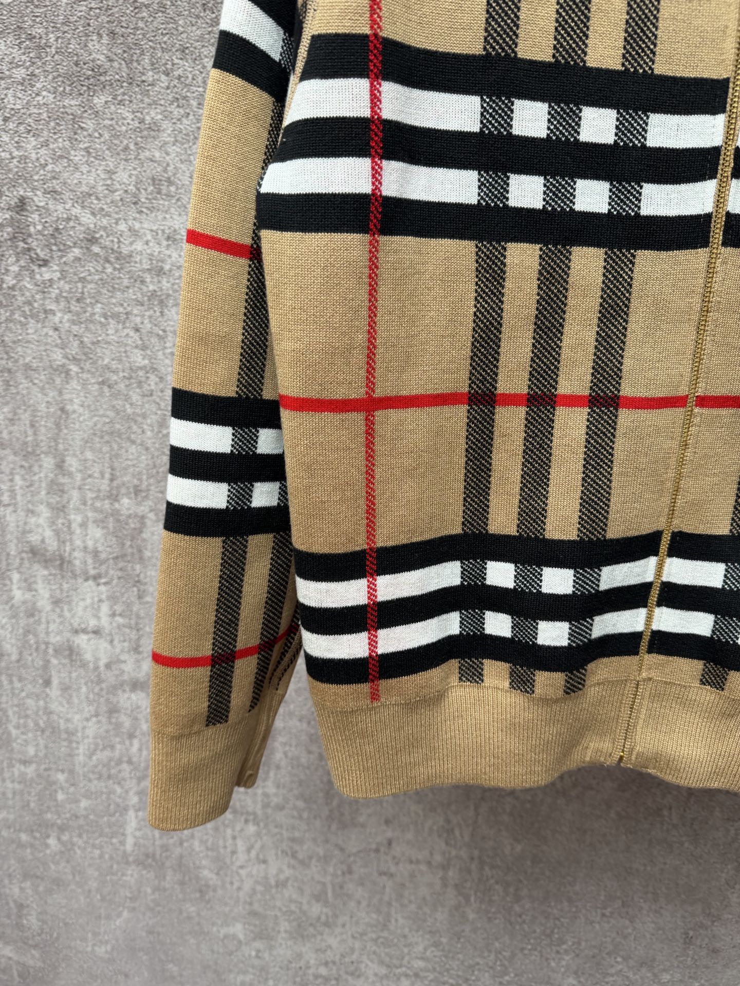 Beige plaid zip-up hoodie hem and sleeve cuff with black stripe bands and red lines