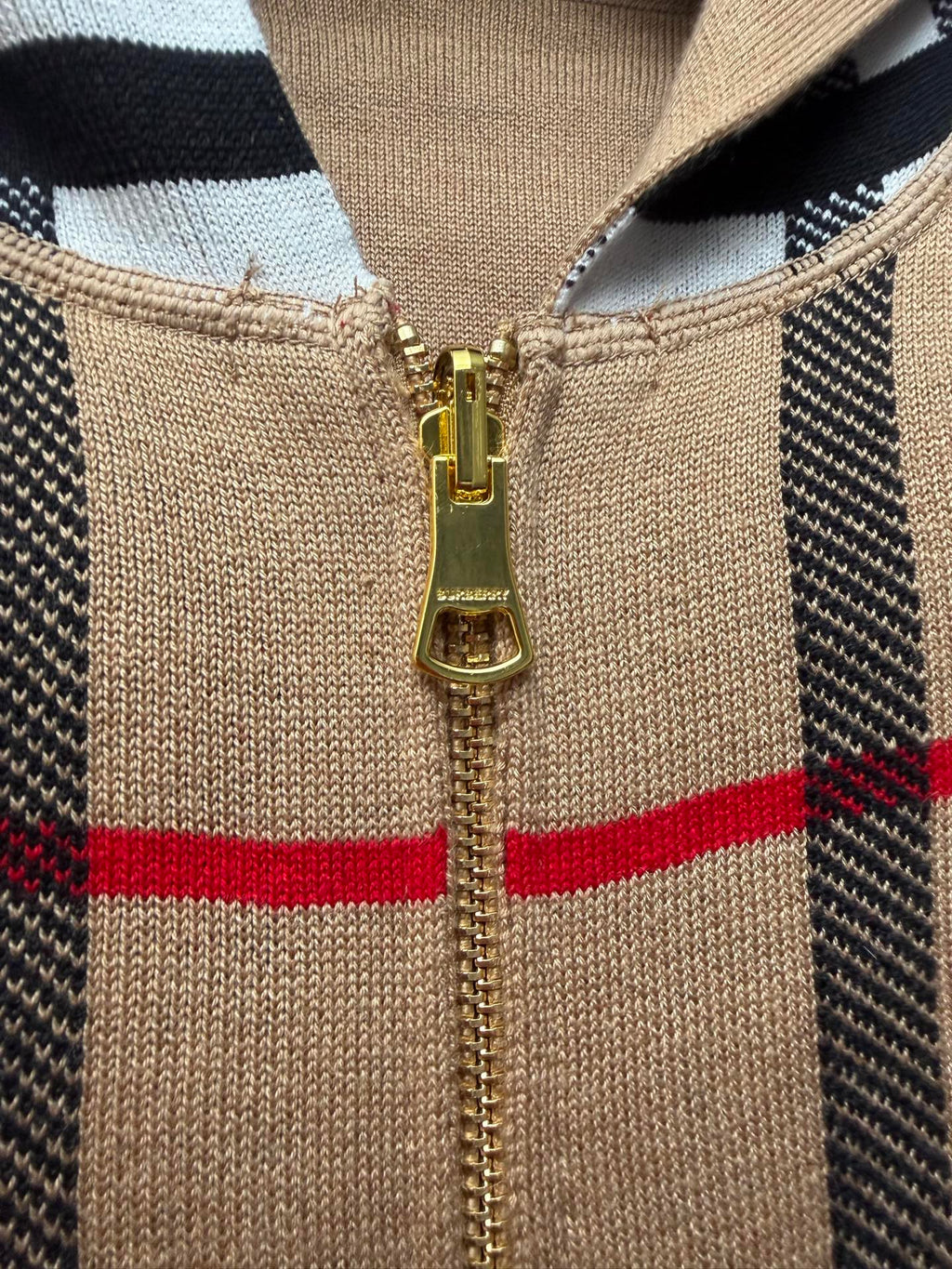Beige knit hoodie zipper front with gold pull, black and plaid panels, hood neckline