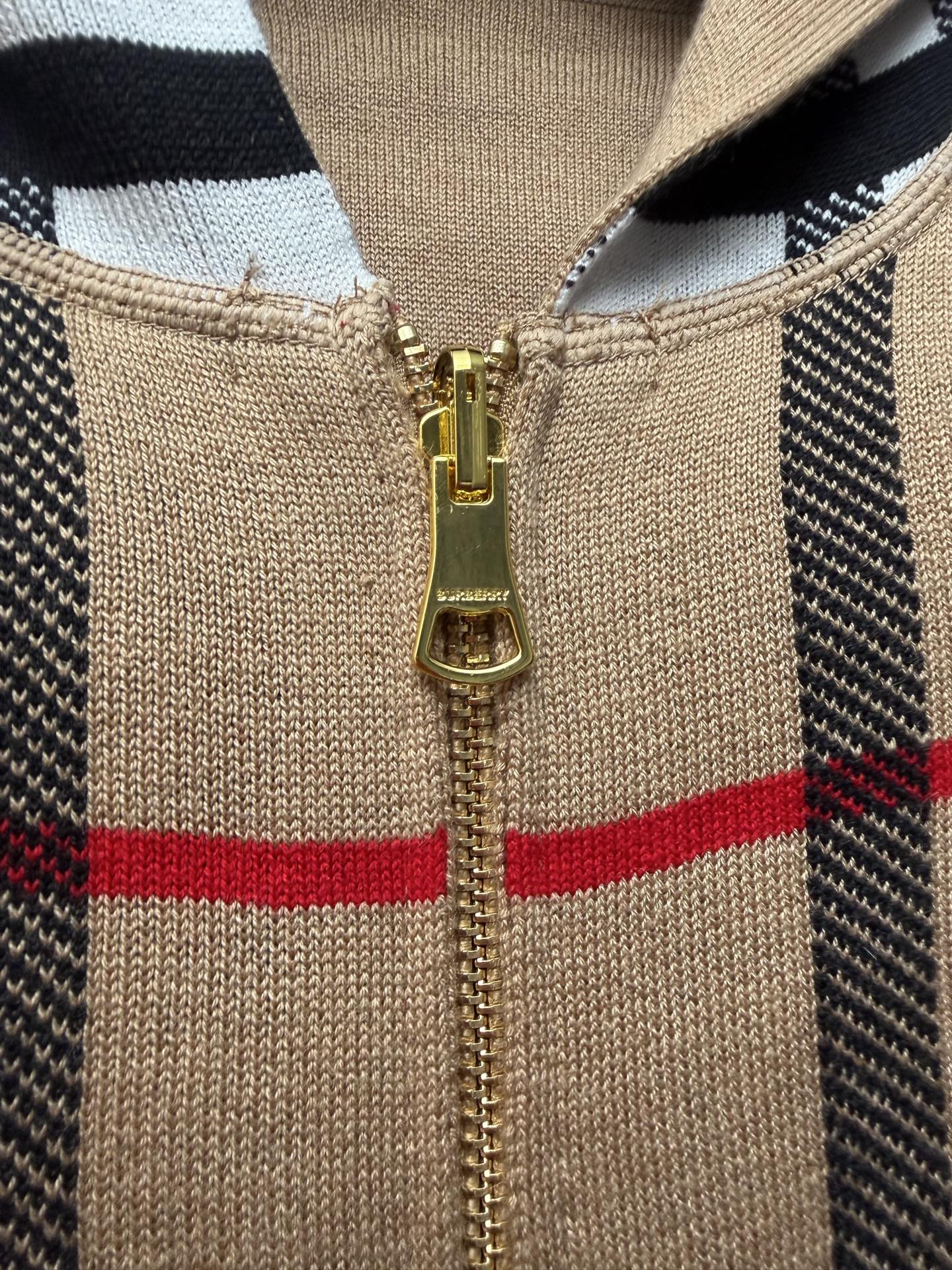 Beige knit hoodie zipper front with gold pull, black and plaid panels, hood neckline