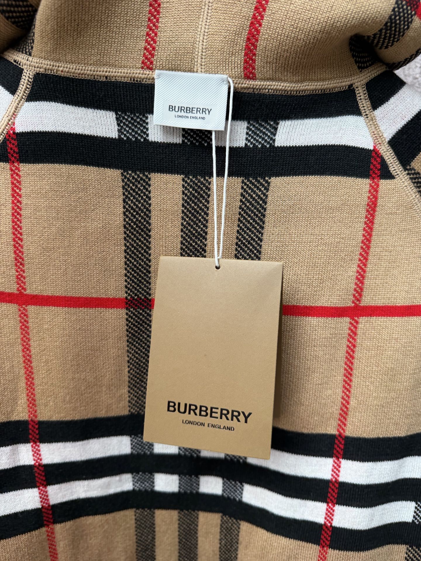 Burberry check polo shirt with red and black stripes, beige and white hem tag