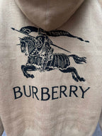 Beige hoodie chest graphic showing navy horse icon and “BURBERRY” text on fabric