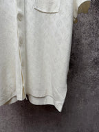 Cream polo shirt hem with button placket and textured fabric