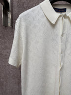 Cream short-sleeve polo shirt with raised monogram pattern and button front