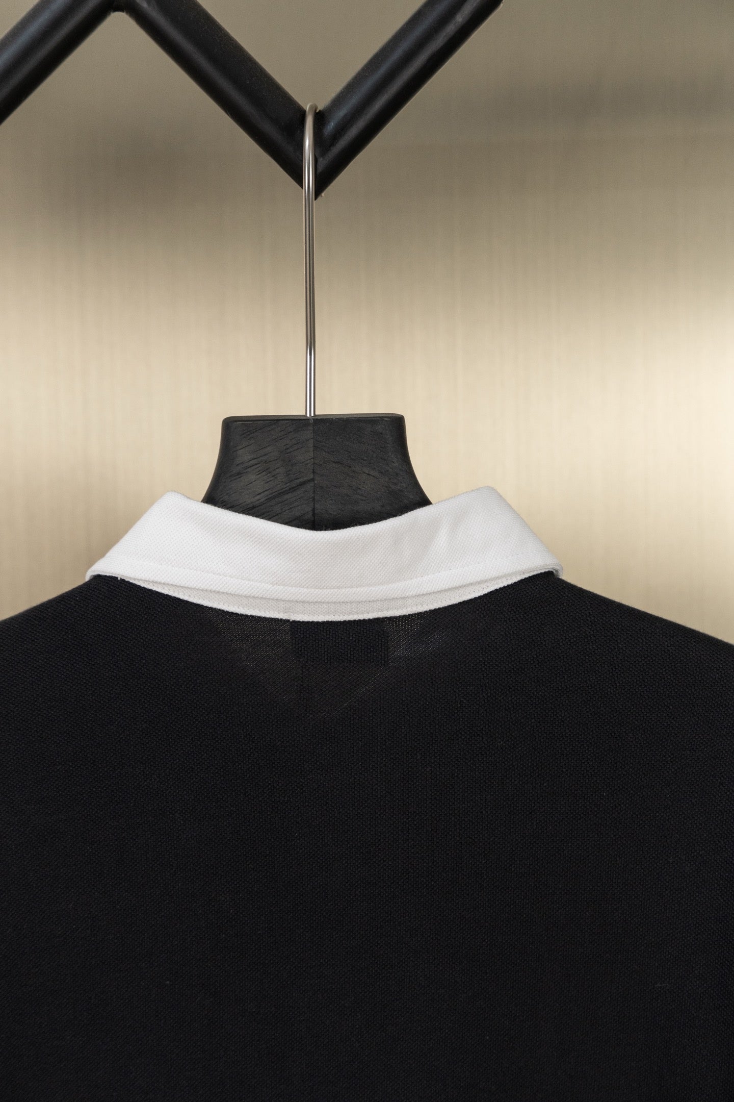 Black polo shirt collar detail in reverse view