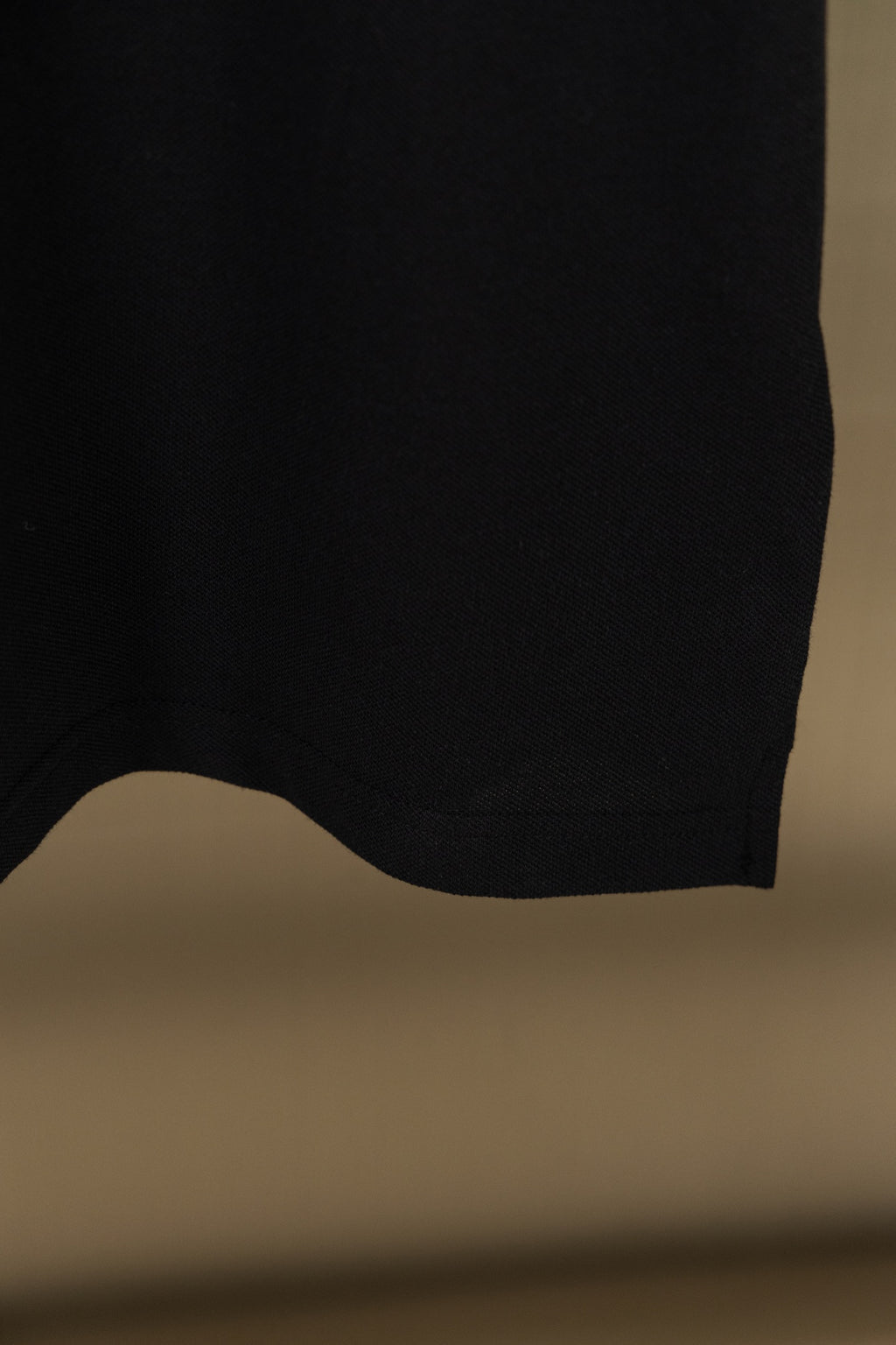 Black polo shirt hem at back with curved cut