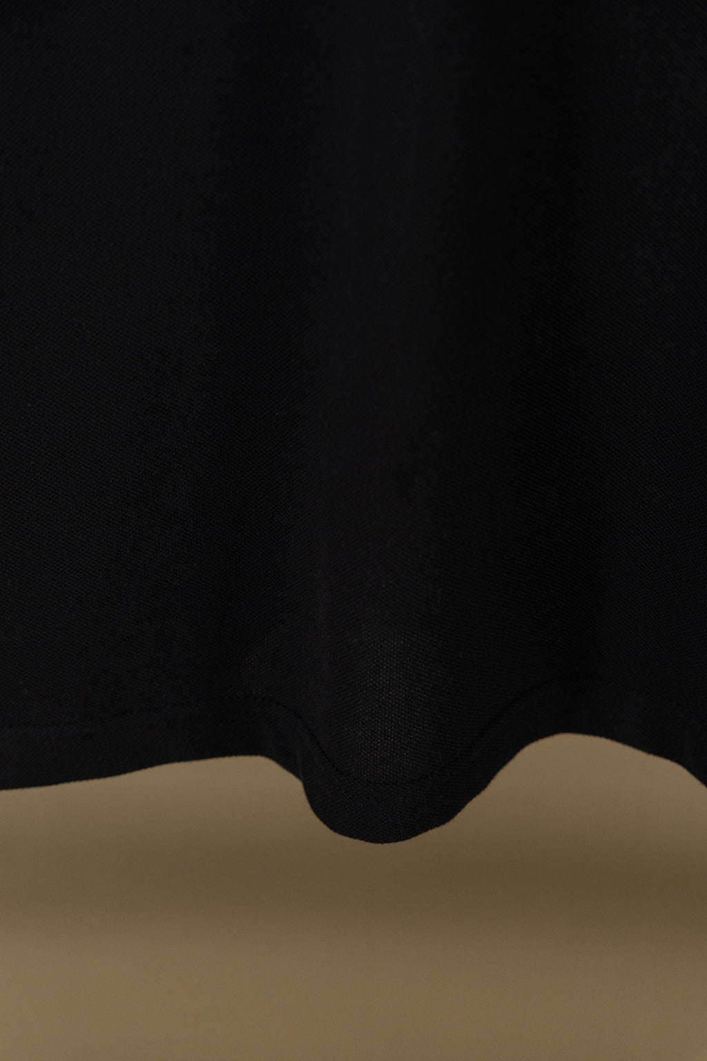 Burberry polo shirt hem with dark fabric and curved bottom