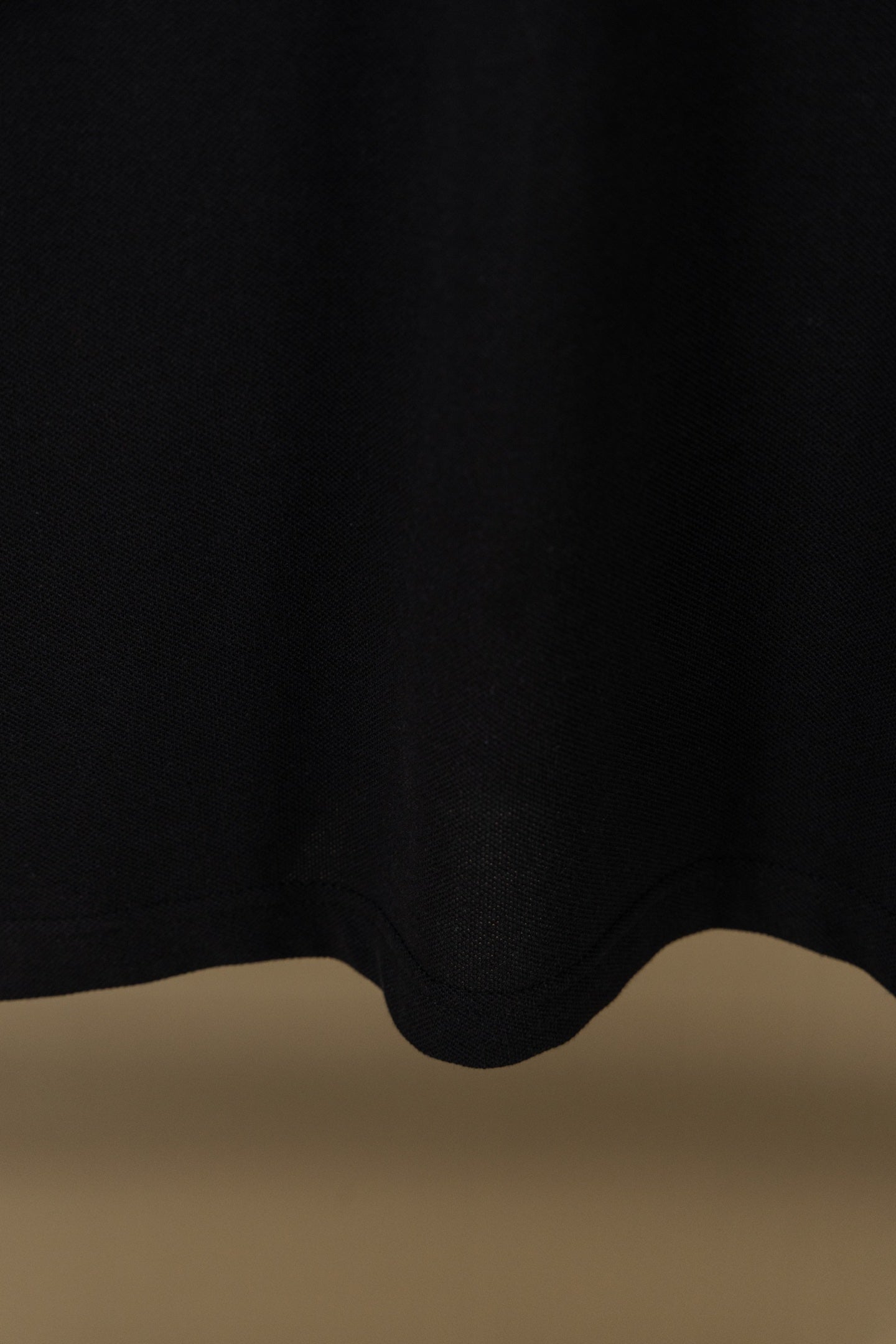 Burberry polo shirt hem with dark fabric and curved bottom
