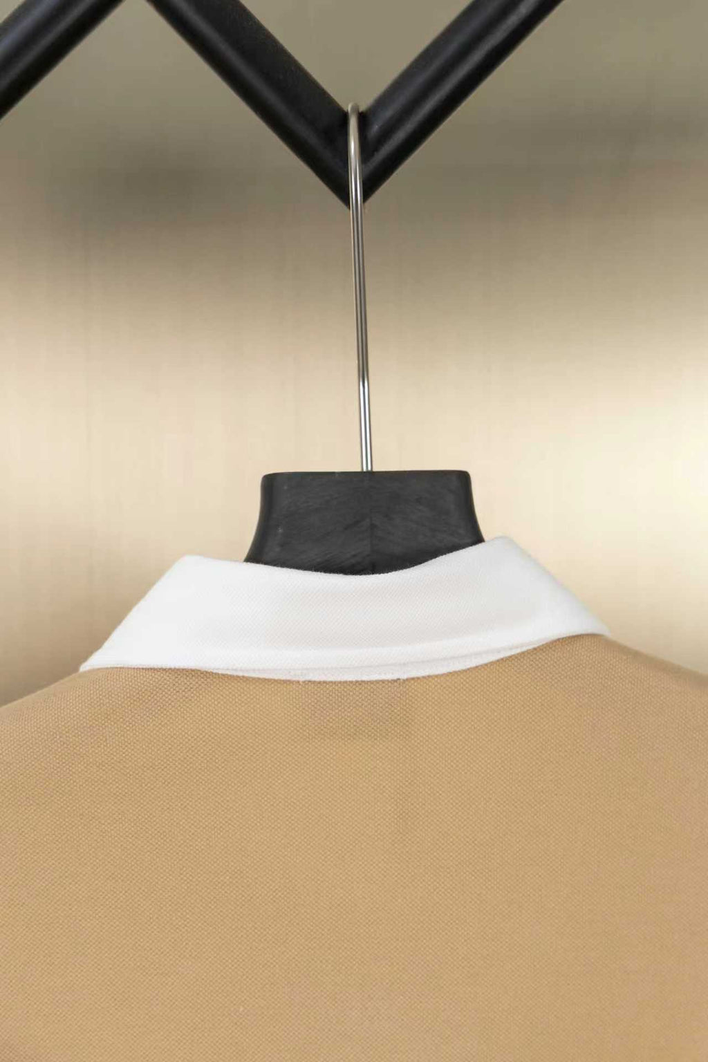 Tan polo shirt neck with white inner collar, back view