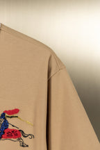 Tan polo shirt sleeve with colorful horse emblem detail