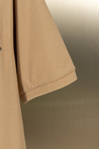 Tan polo shirt sleeve hem with stitched cuff edge