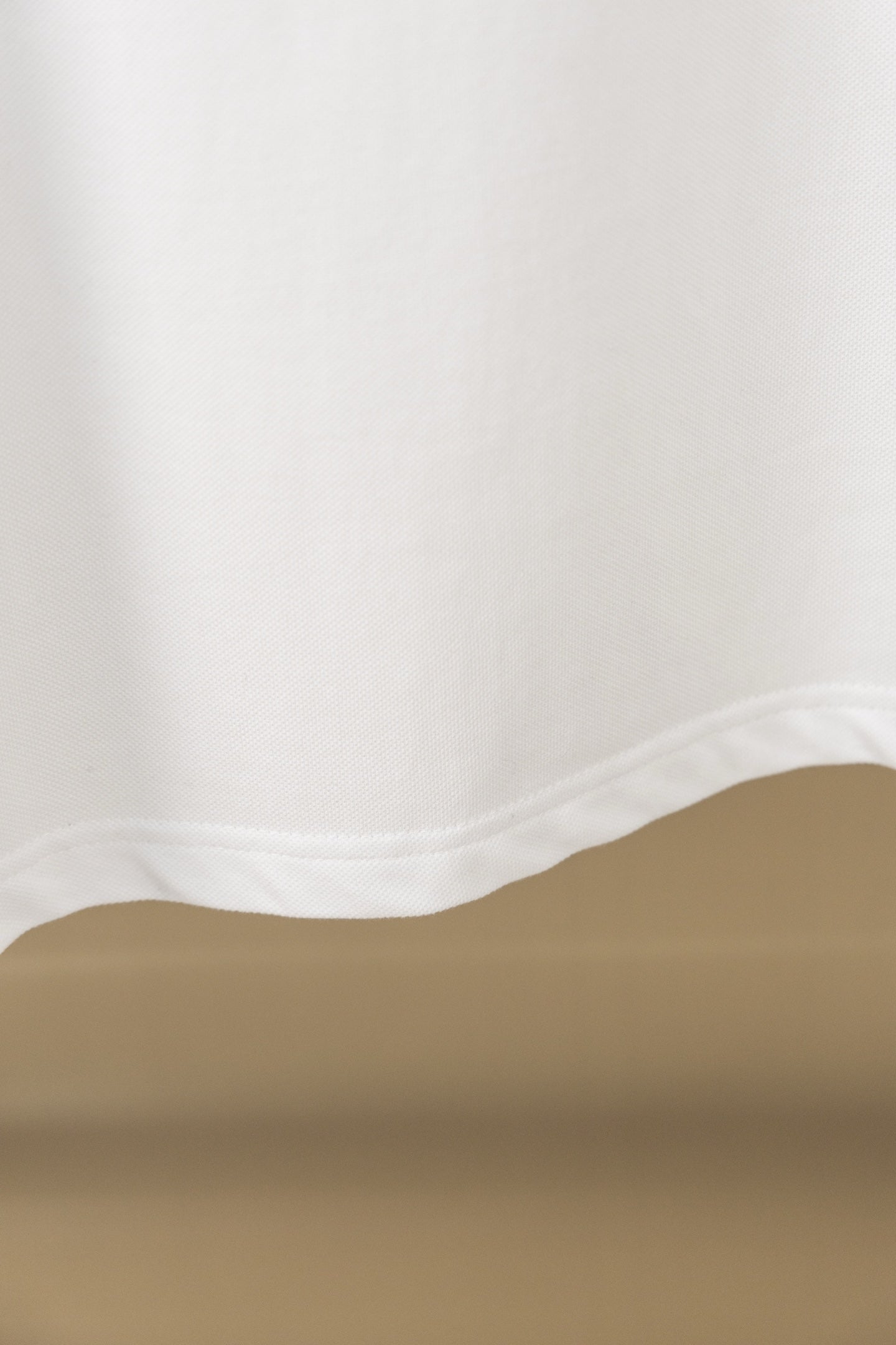 White polo shirt fabric hem and side seam close-up