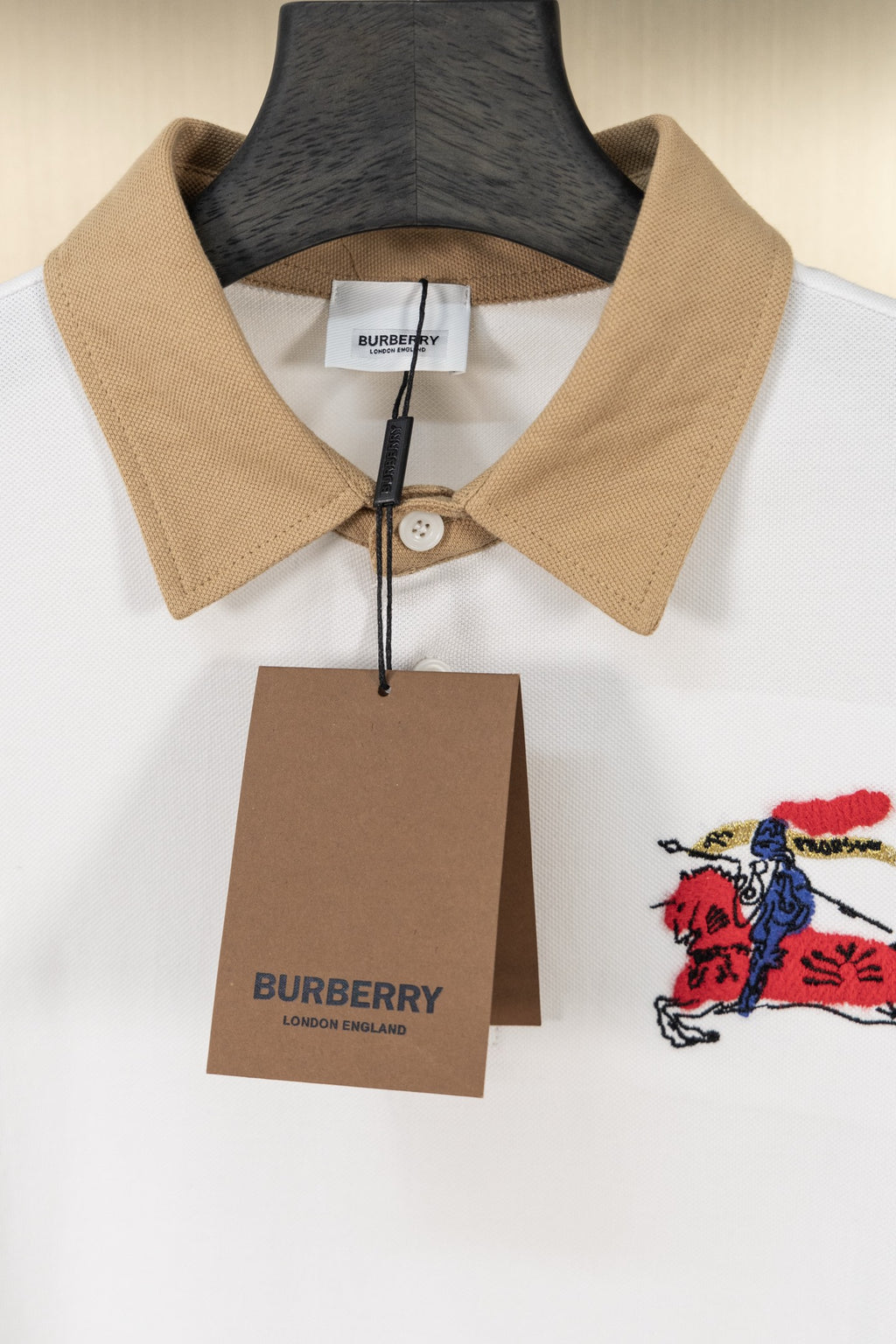 Burberry polo shirt with tan collar, button placket, and Burberry gift tag