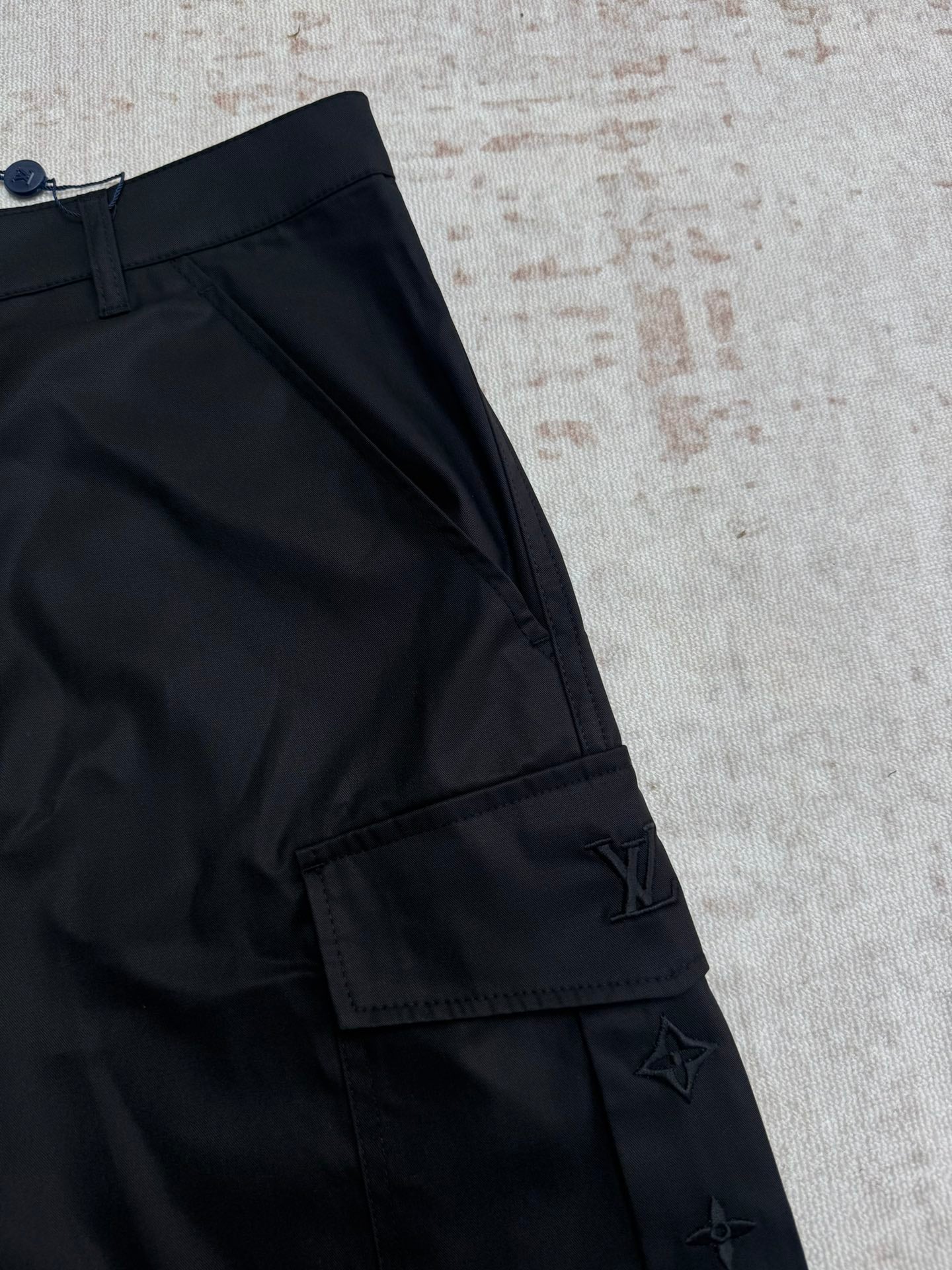 Black pants leg with side cargo pocket and Louis Vuitton emblem
