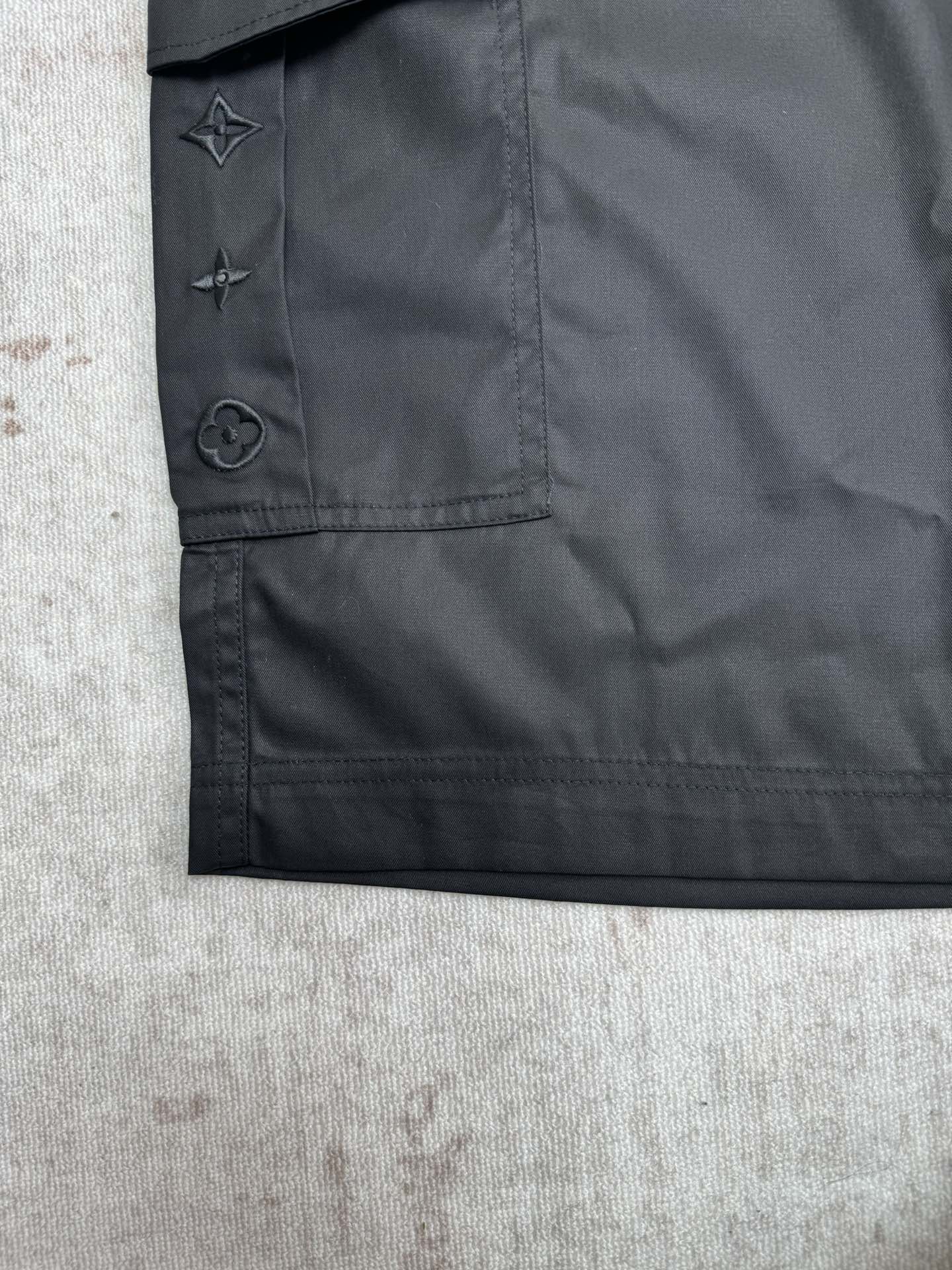 Black cargo pants pocket flap with star and circular emblem logos