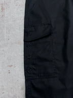 Black cargo pants with stitched emblem patches on pocket flap