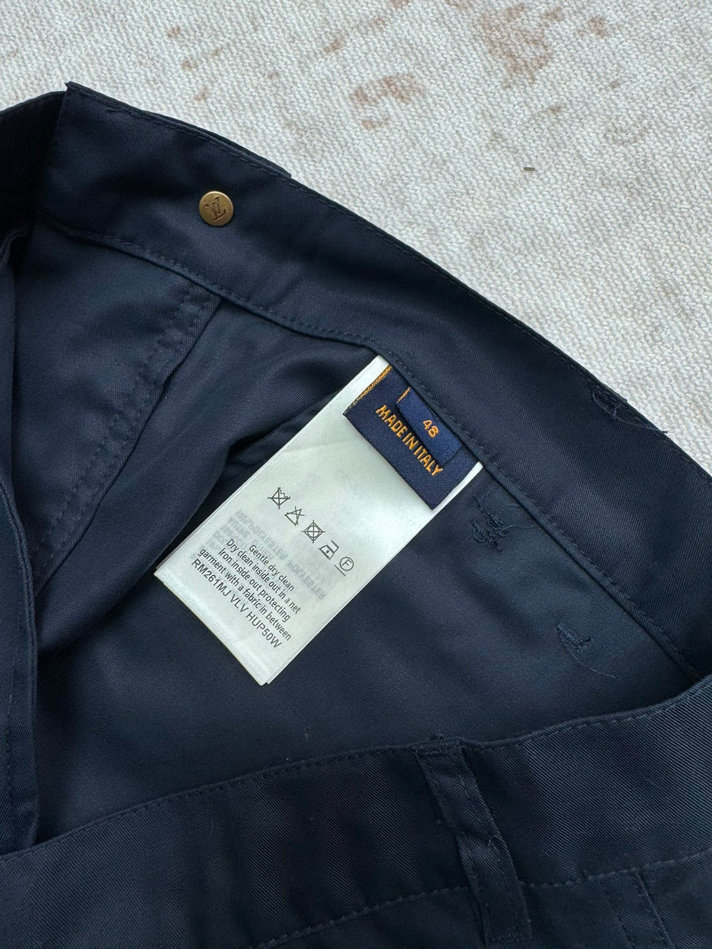 Navy Louis Vuitton shorts interior with care label and gold button.