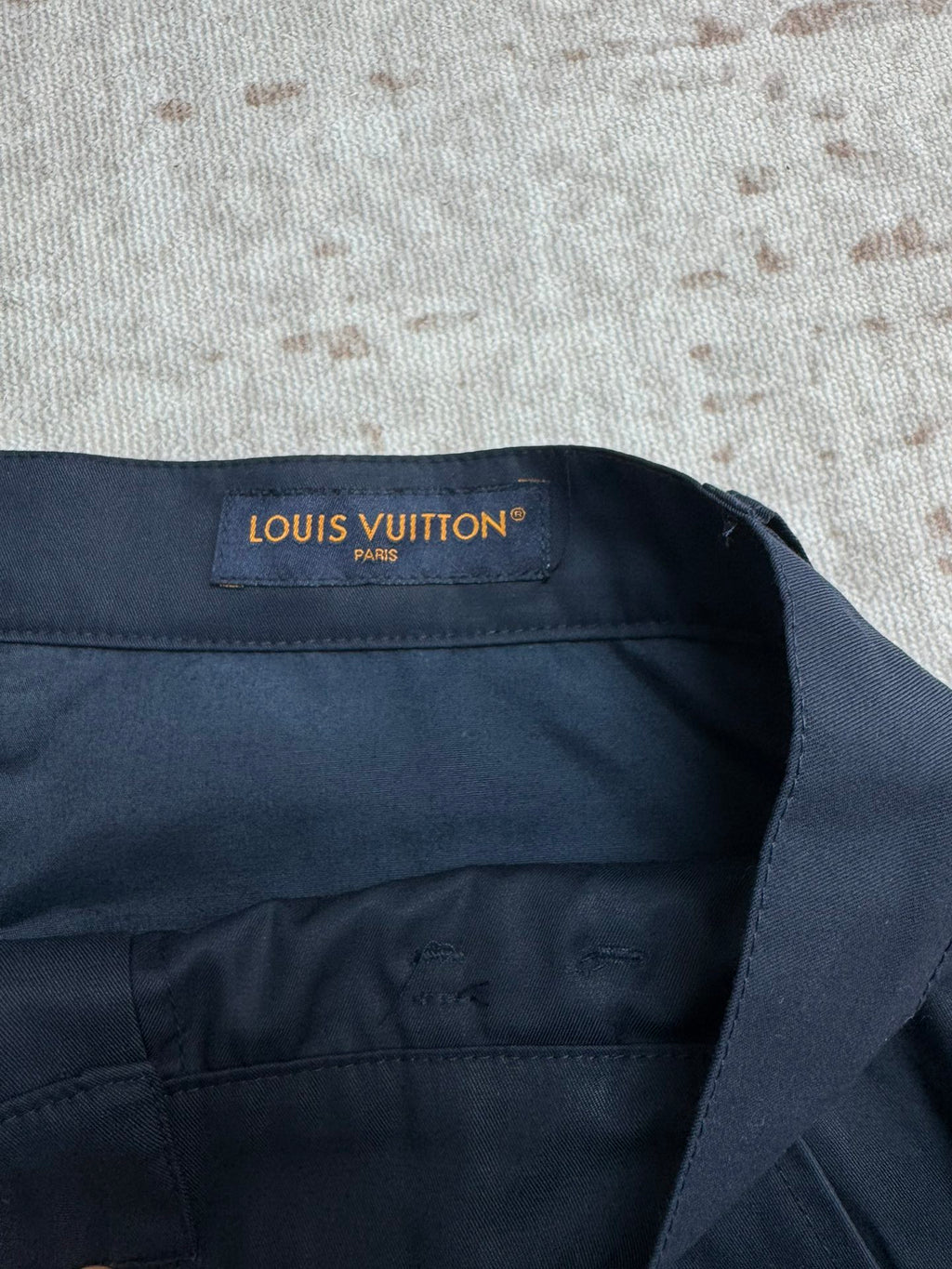 Navy Louis Vuitton shorts waistband label with button fly.