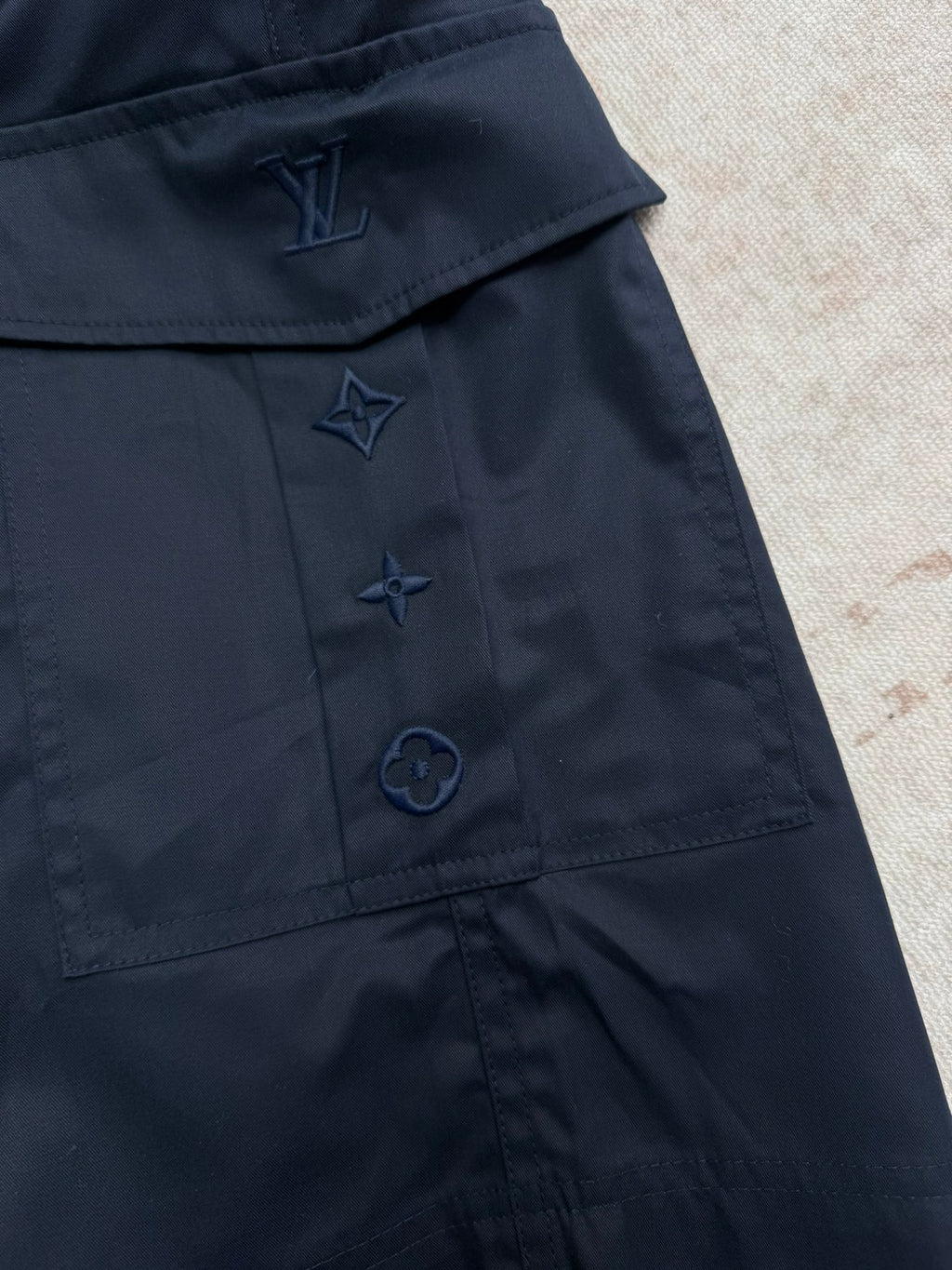 Navy Louis Vuitton shorts with embroidered star and logo-style pocket detailing.