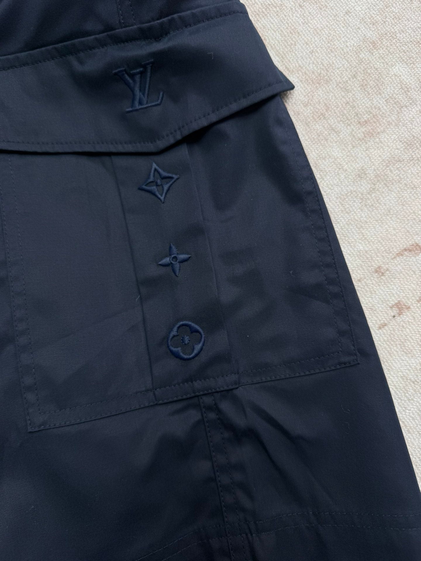 Navy Louis Vuitton shorts with embroidered star and logo-style pocket detailing.
