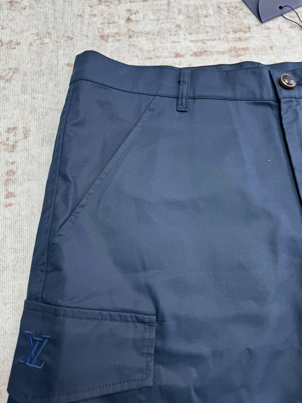 Navy Louis Vuitton shorts front with belt loops and deep cargo pocket.