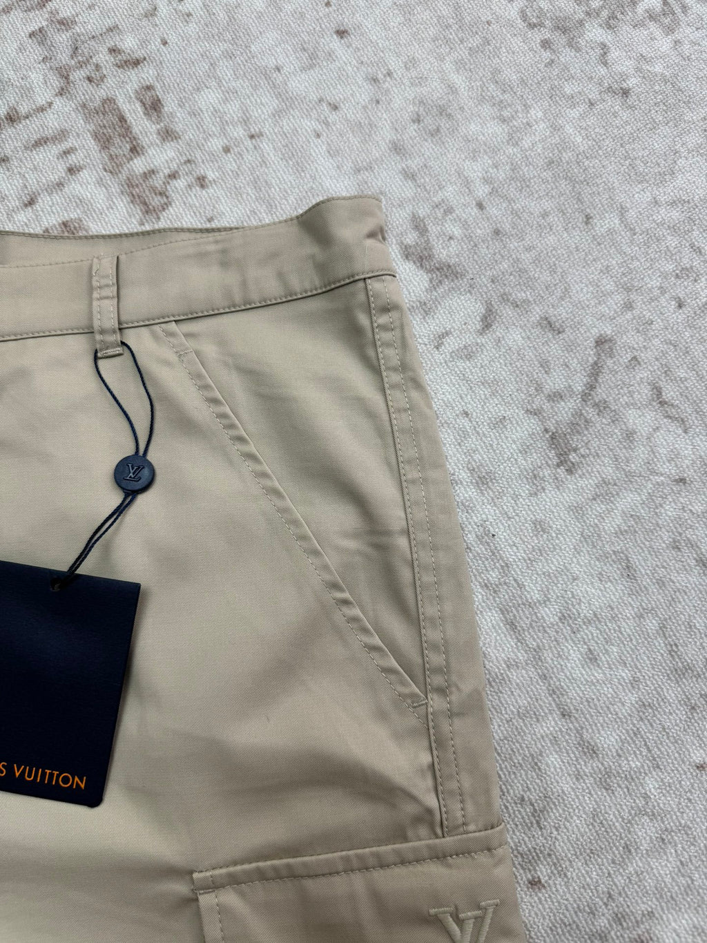 Beige shorts back view with drawstring tag and logo print patch