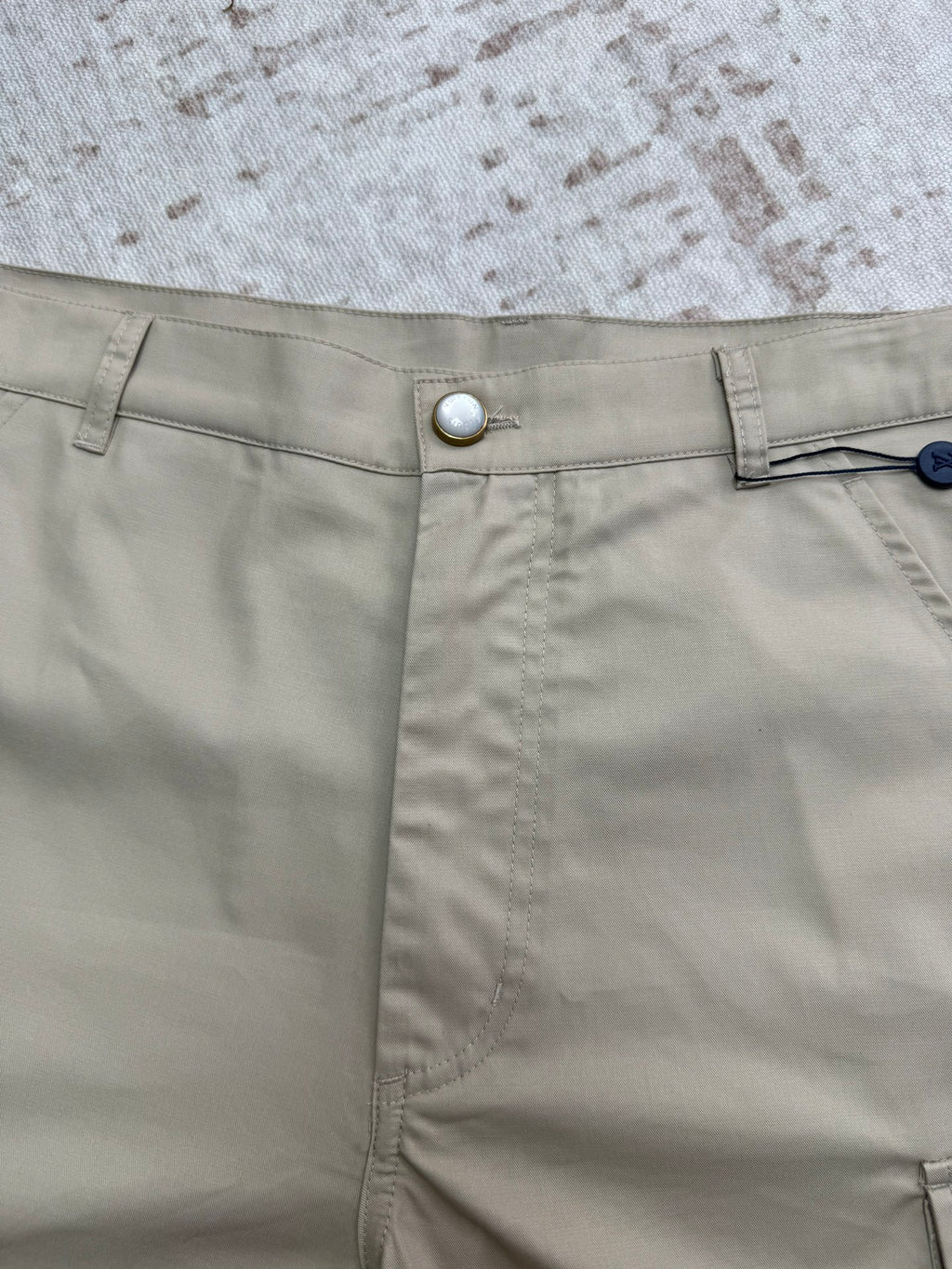 Beige shorts waistband with silver button and stitched side seams