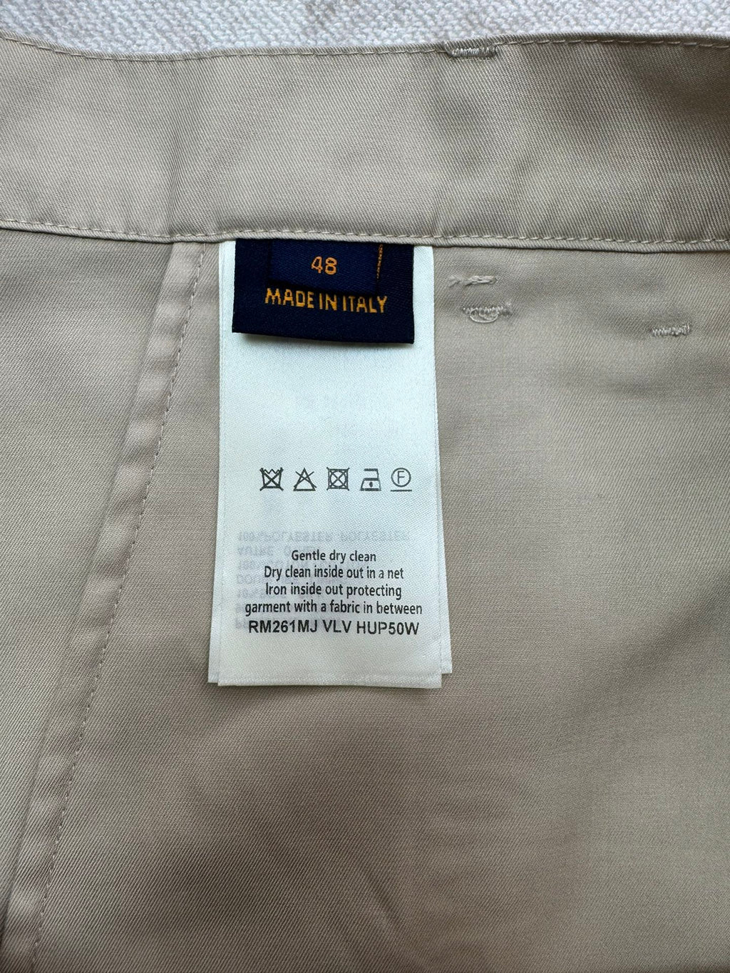 Beige shorts care label and size tag sewn into inner waistband