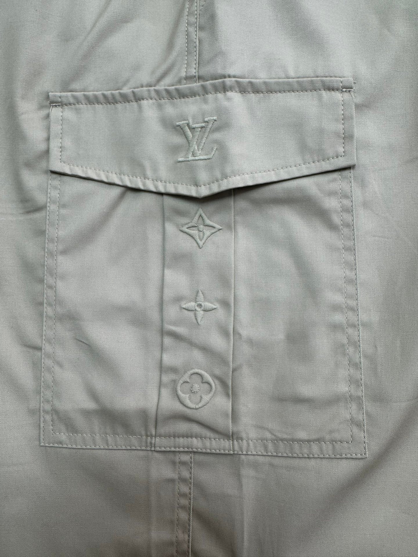 Beige shorts interior with LV emblem patch and decorative stitched motifs