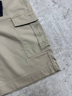 Beige cargo shorts detail with stitched logo patch and inner tag