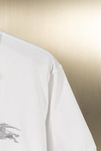 White polo shirt side view with short sleeve and embroidered logo detail