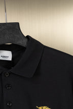 Burberry black polo shirt close-up of placket and gold horse logo