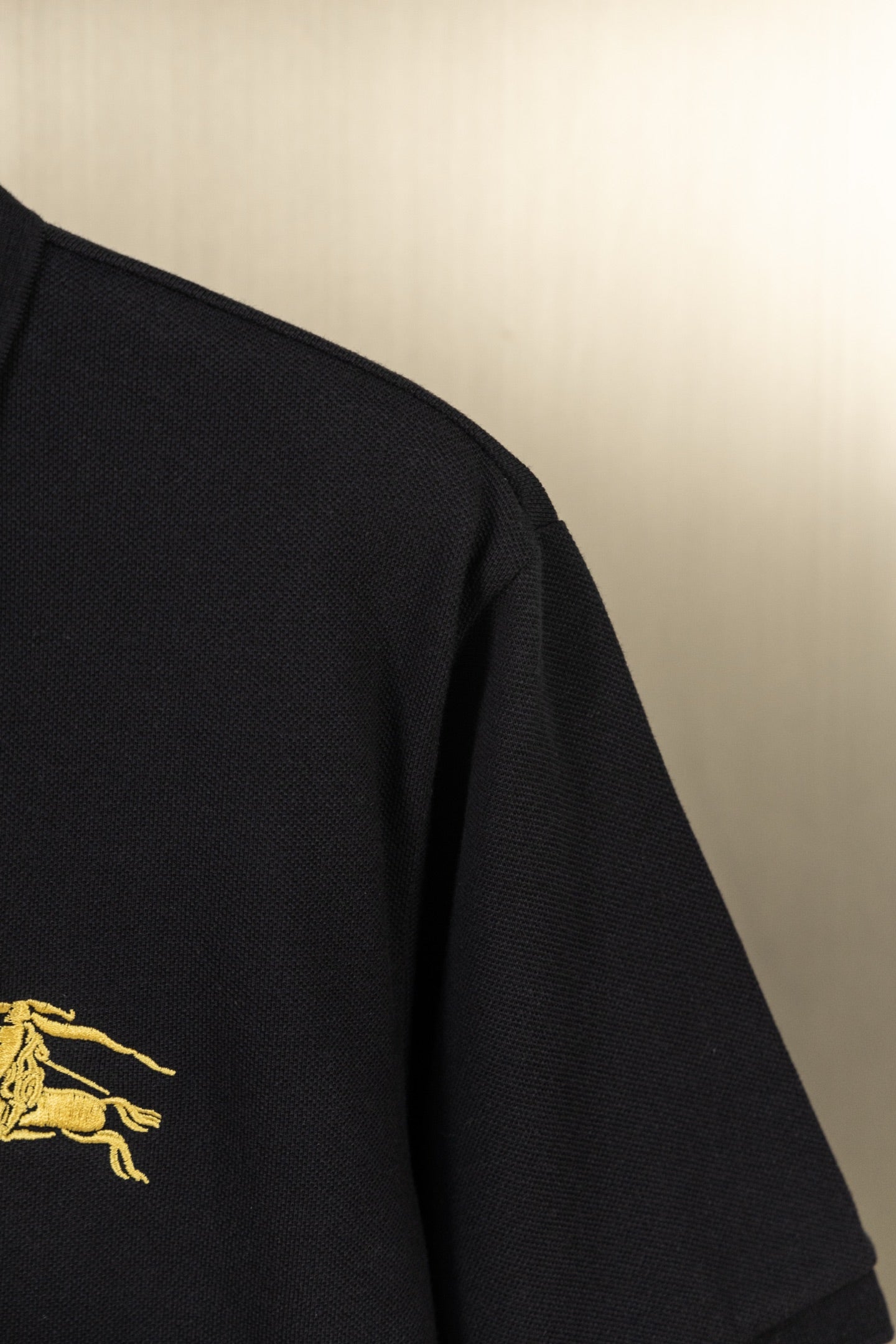 Burberry black polo shirt side with gold horse logo