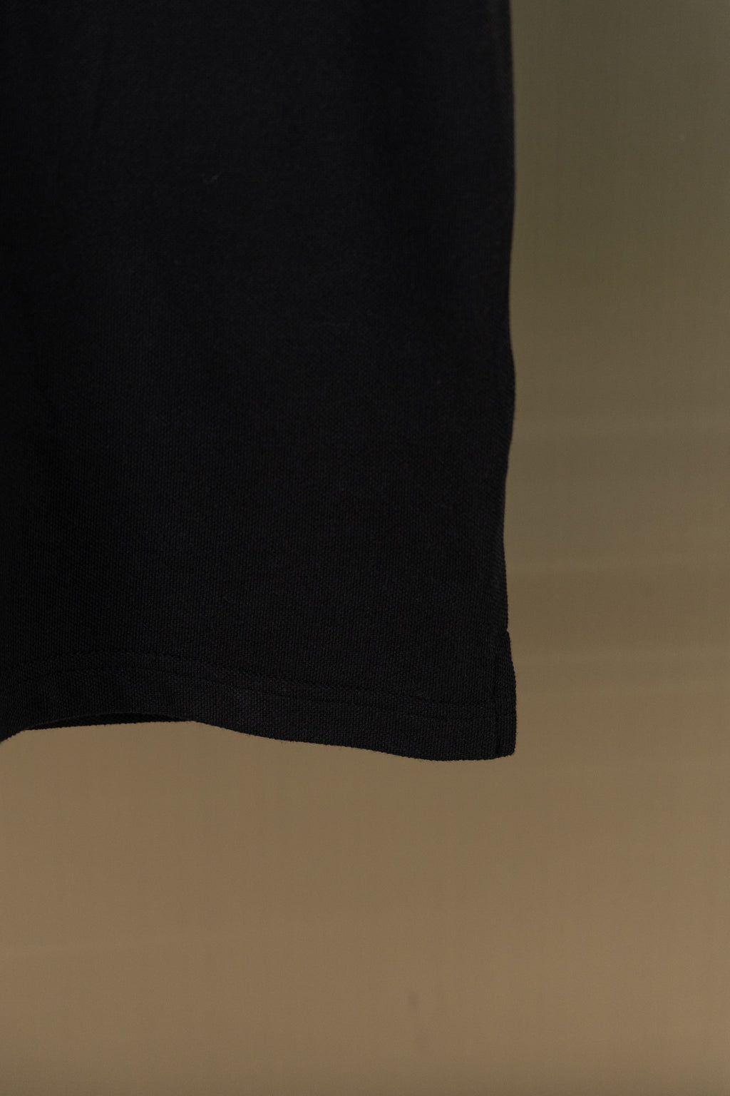 Burberry black polo shirt hem, side view