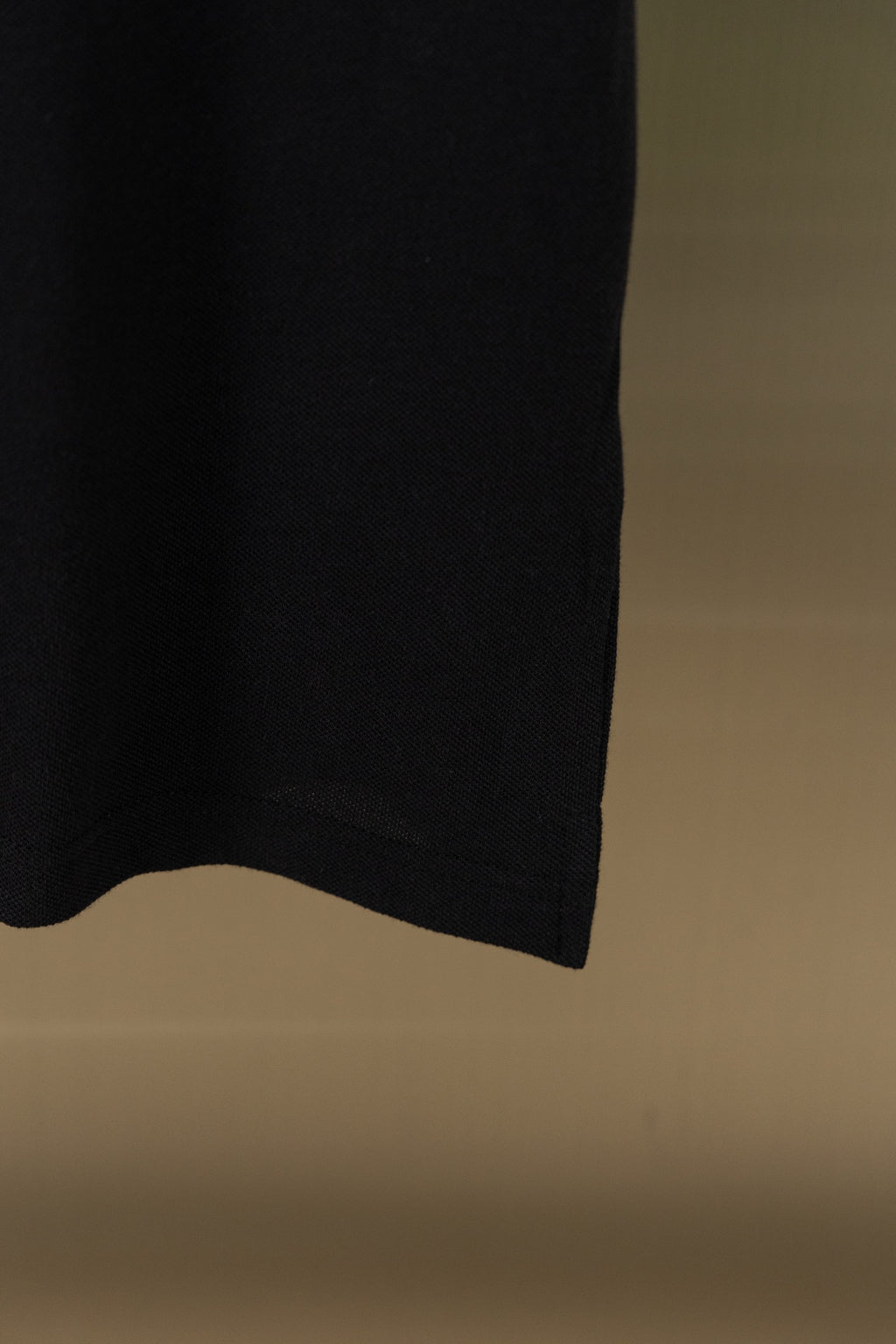 Black polo shirt side hem and lower edge detail