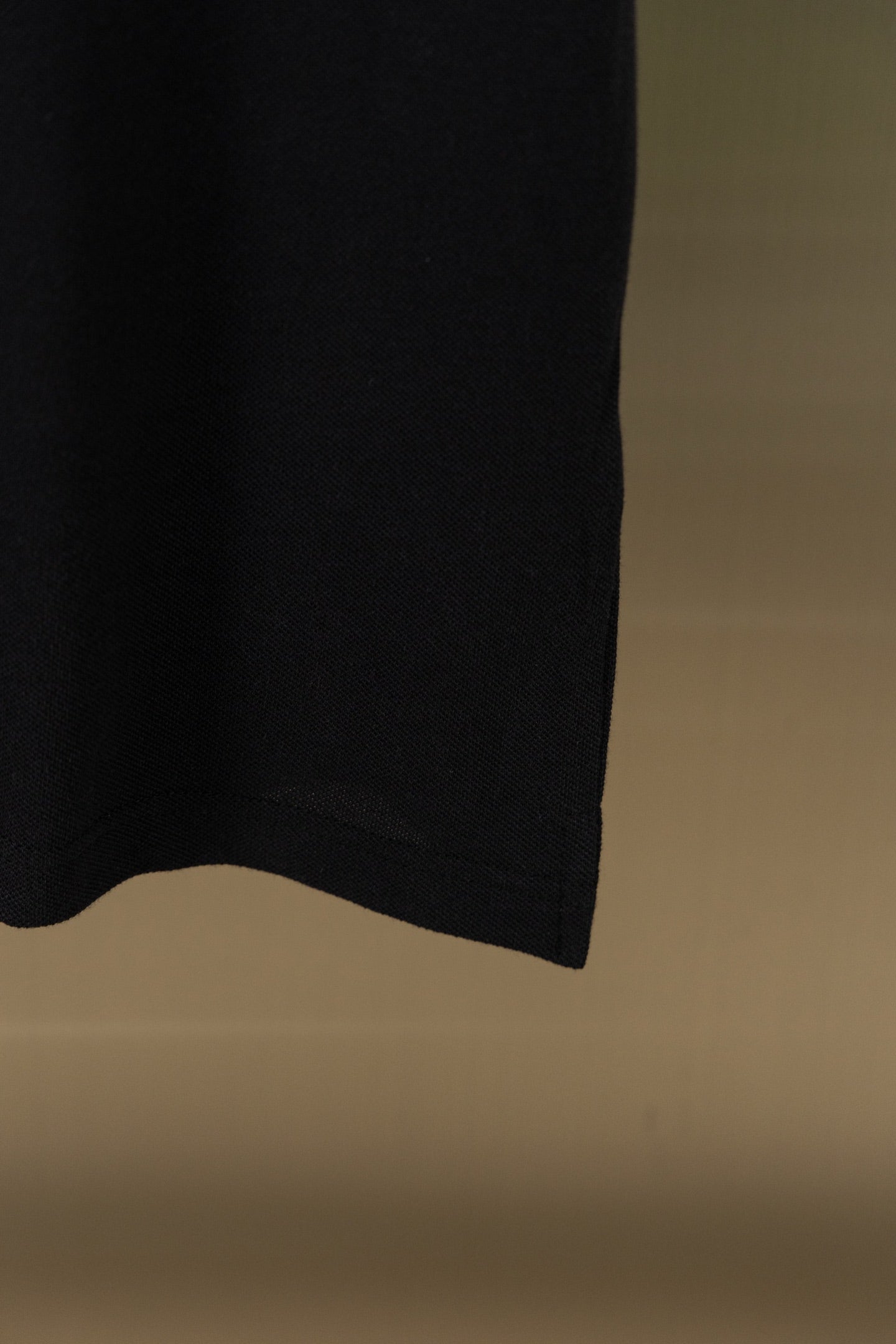 Black polo shirt side hem and lower edge detail